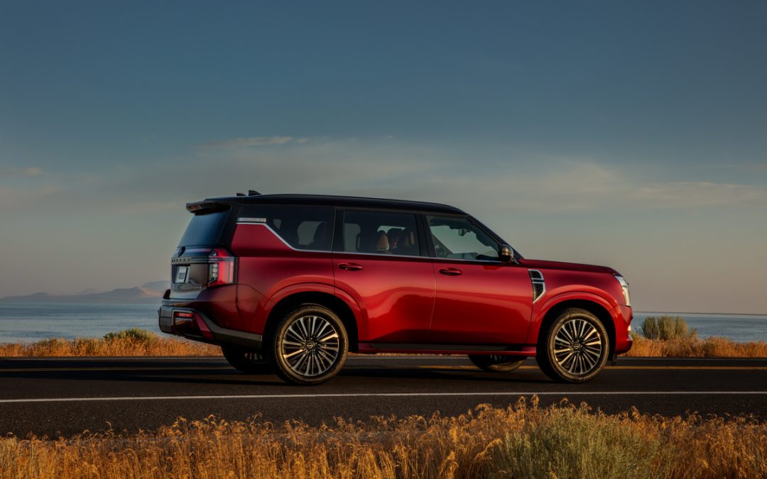 Red Nissan Armada SUV shown in side profile on a scenic road